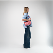 A Red Gingham Convertible Clutch being used by a model