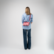 A Red Gingham Convertible Clutch being used by a model