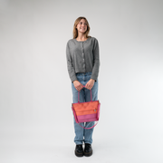 The Coral N Fuchsia Mini Streamline Tote being held in a model's hands