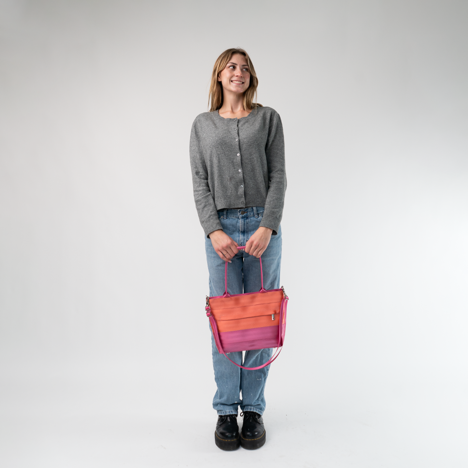 The Coral N Fuchsia Mini Streamline Tote being held in a model's hands