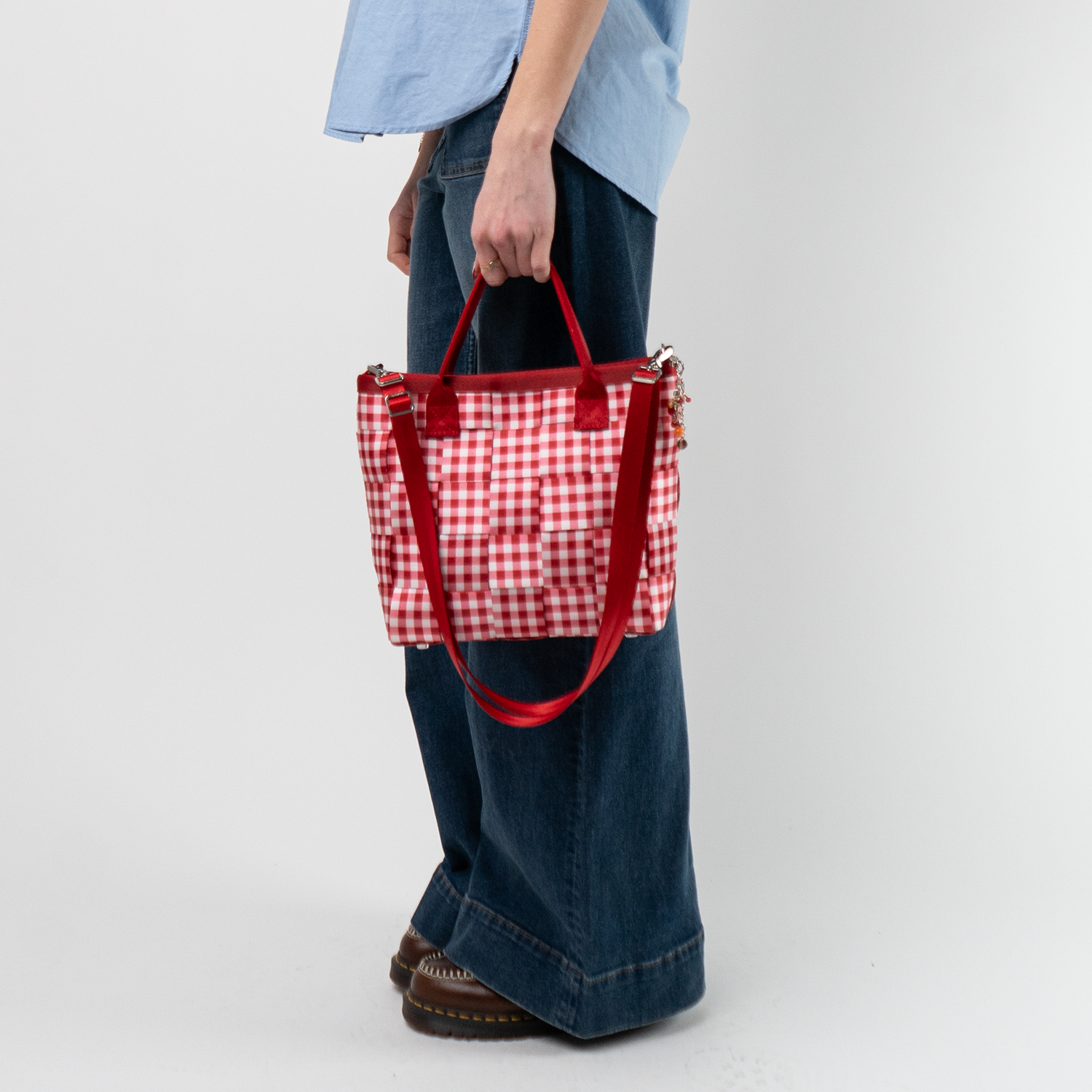 A Red Gingham Crossbody Tote being used by a model