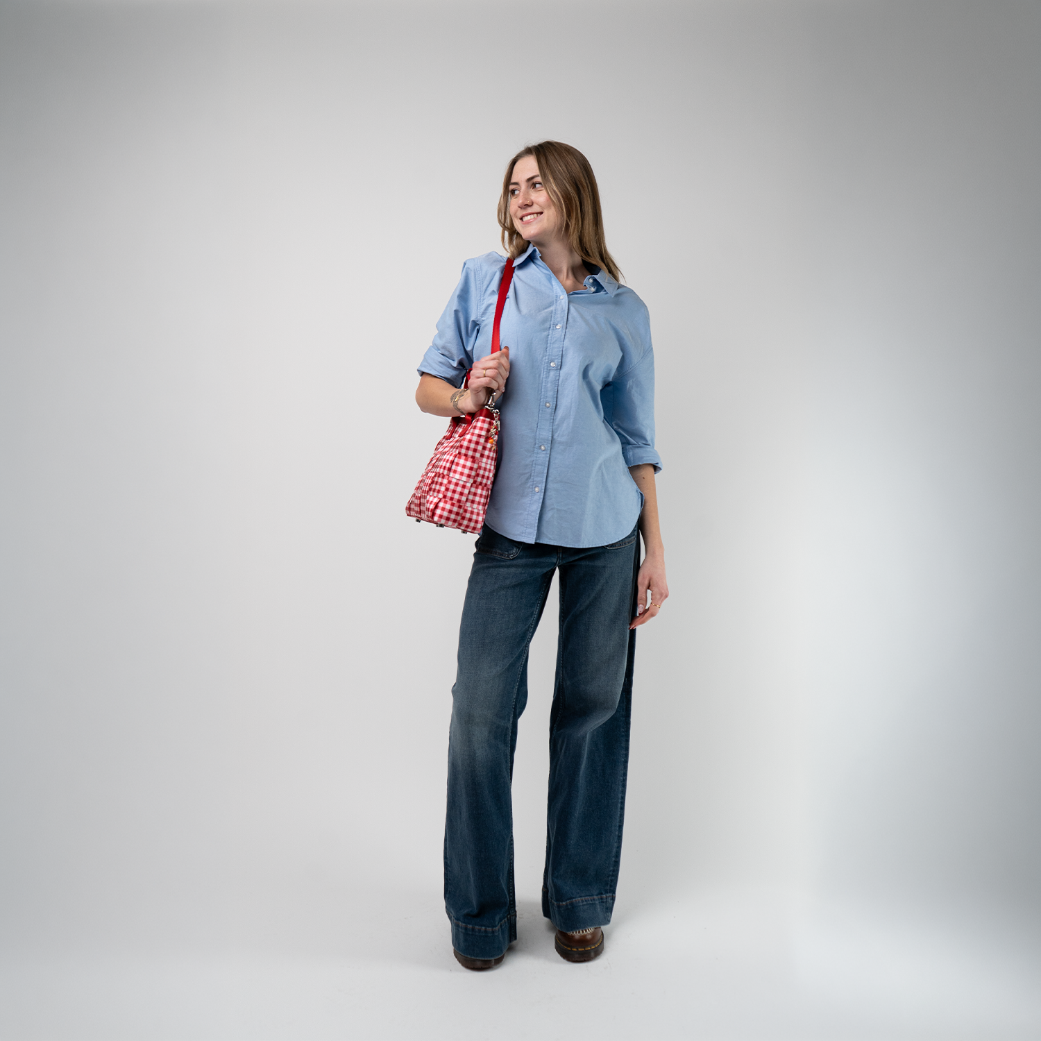 A Red Gingham Crossbody Tote being used by a model