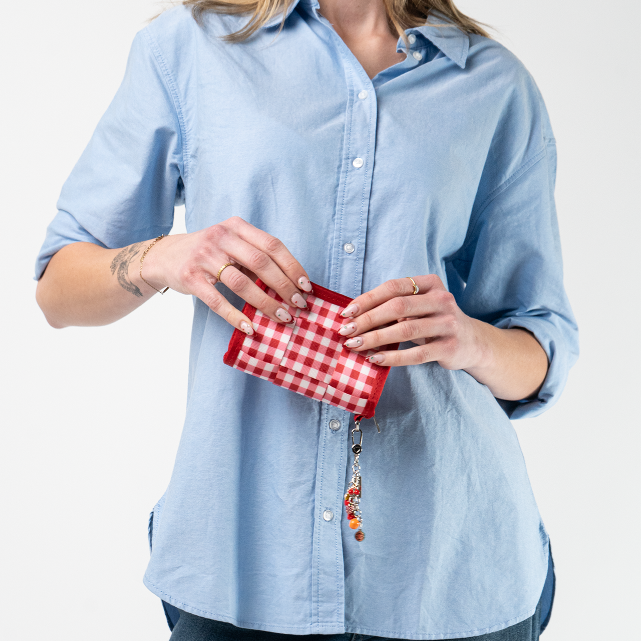 A Red Gingham Fun Size Wallet being used by a model