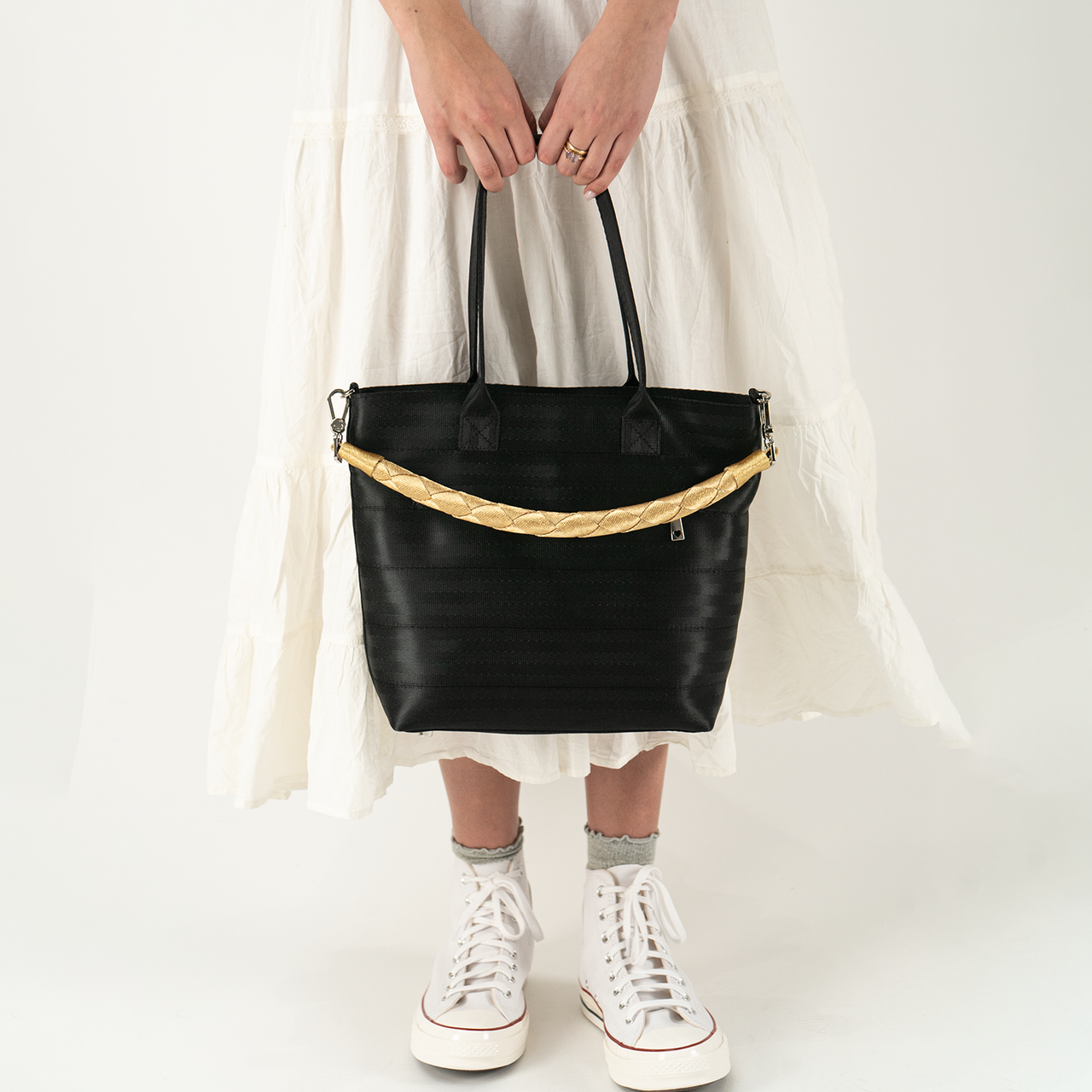 A Lola Click N Carry in the color Gold being used on a bag