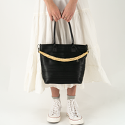 A Lola Click N Carry in the color Gold being used on a bag