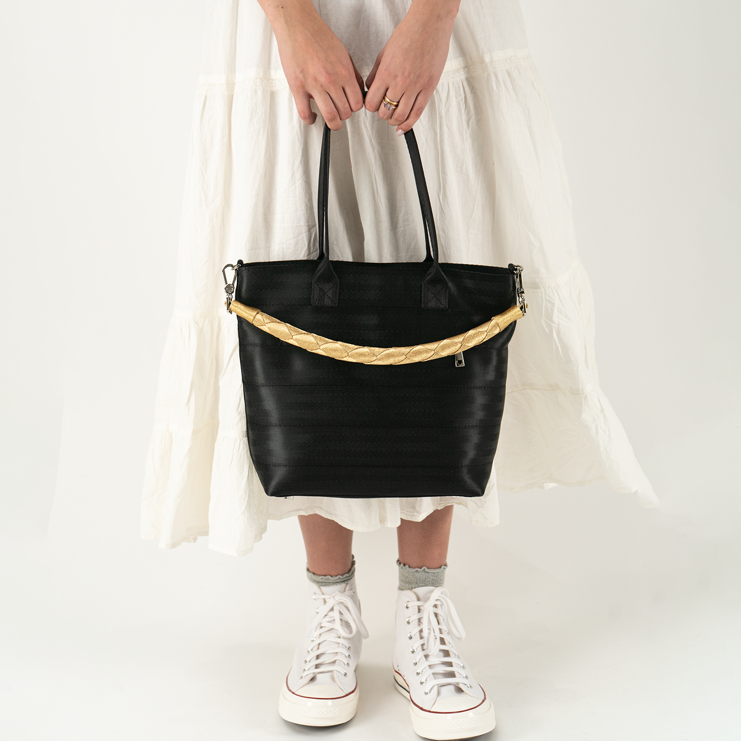 A Lola Click N Carry in the color Gold being used on a bag