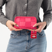 A Classic Wallet in Melon being held in a Model's hands