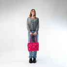 A Large Tote in Melon being held in a Model's hands