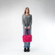 A Large Tote in Melon being held in a Model's hands