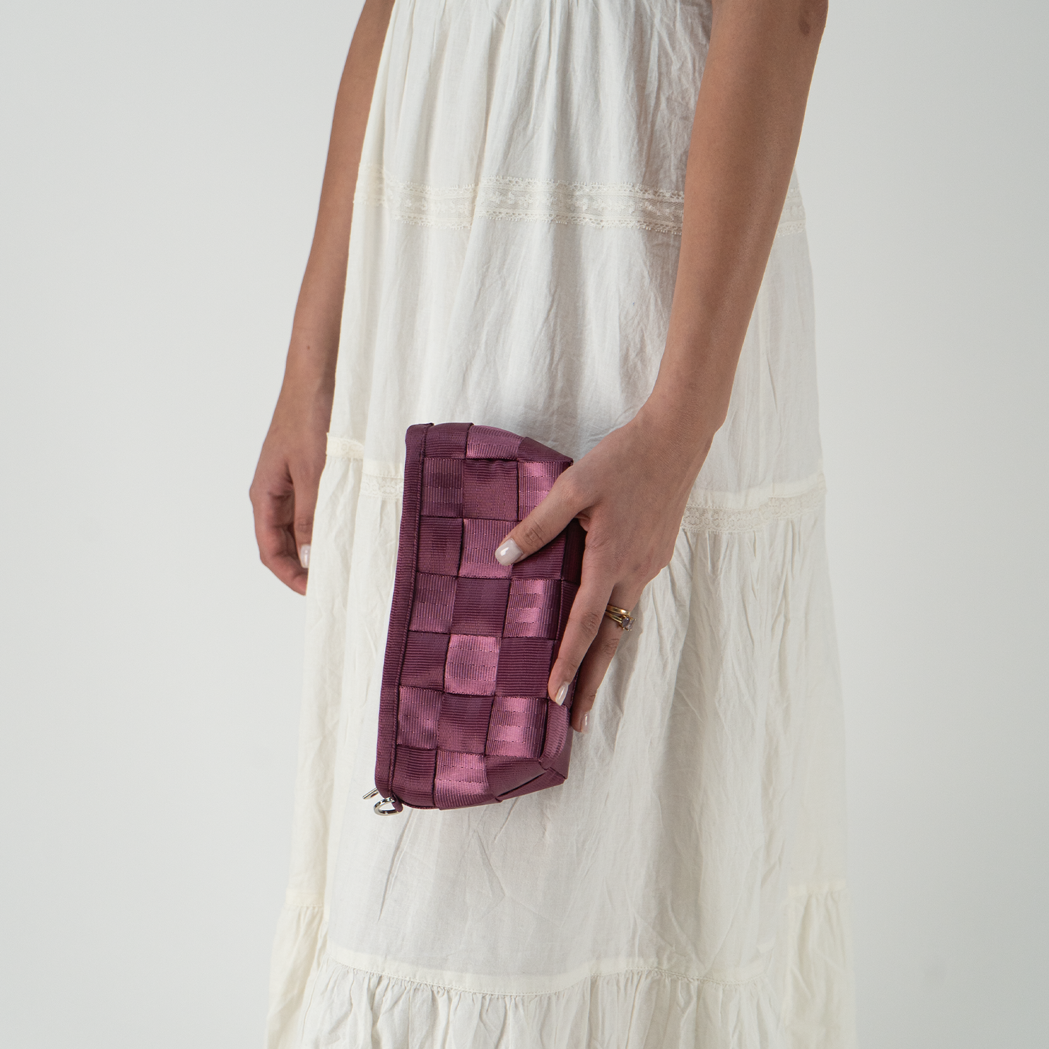 A Plum Triangle Makeup Case in a models hand