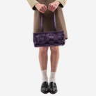 The Satchel in Blackberry being held by a model