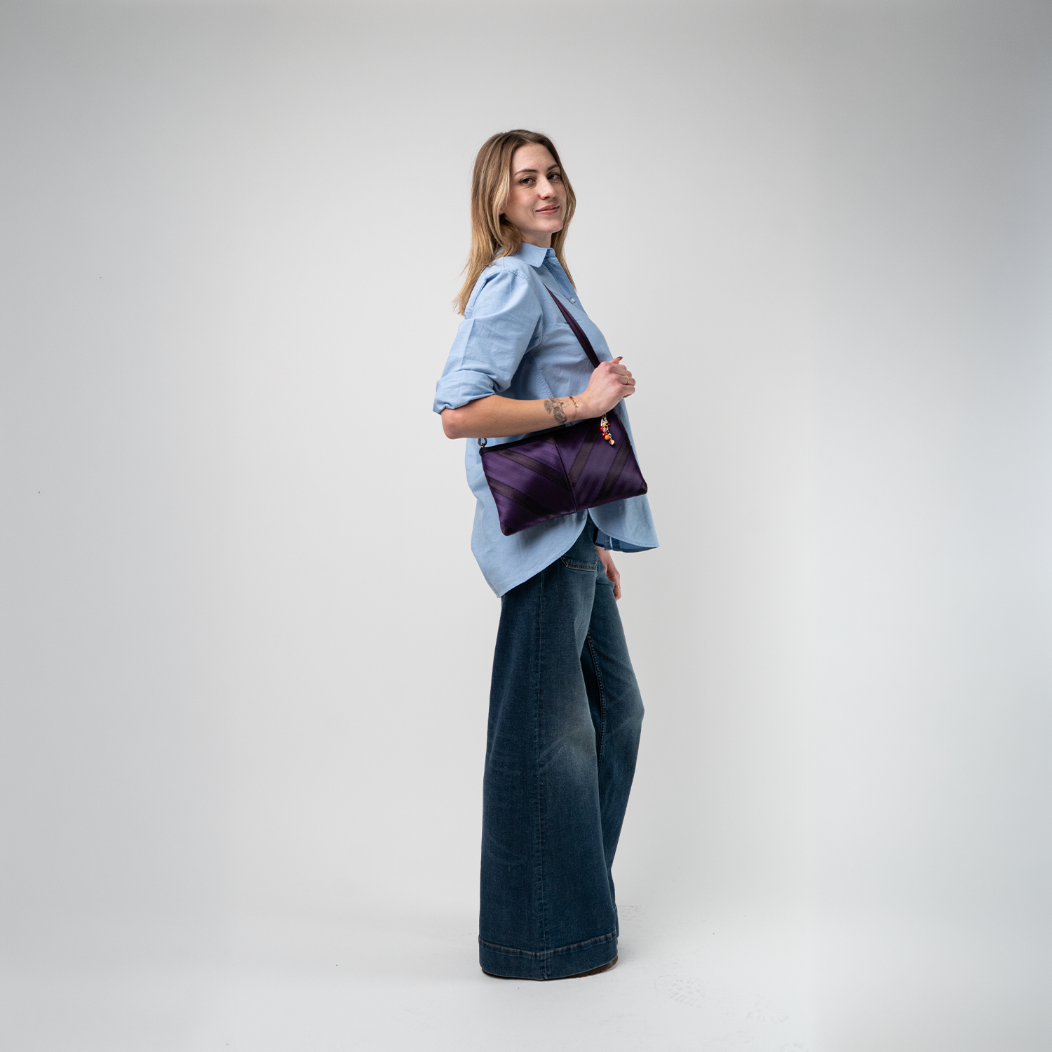 A Grape Soda Sydney Clutch being used by a model