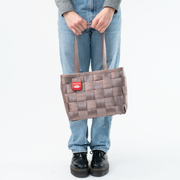 A Taupe Large Tote being held in a Model's hands