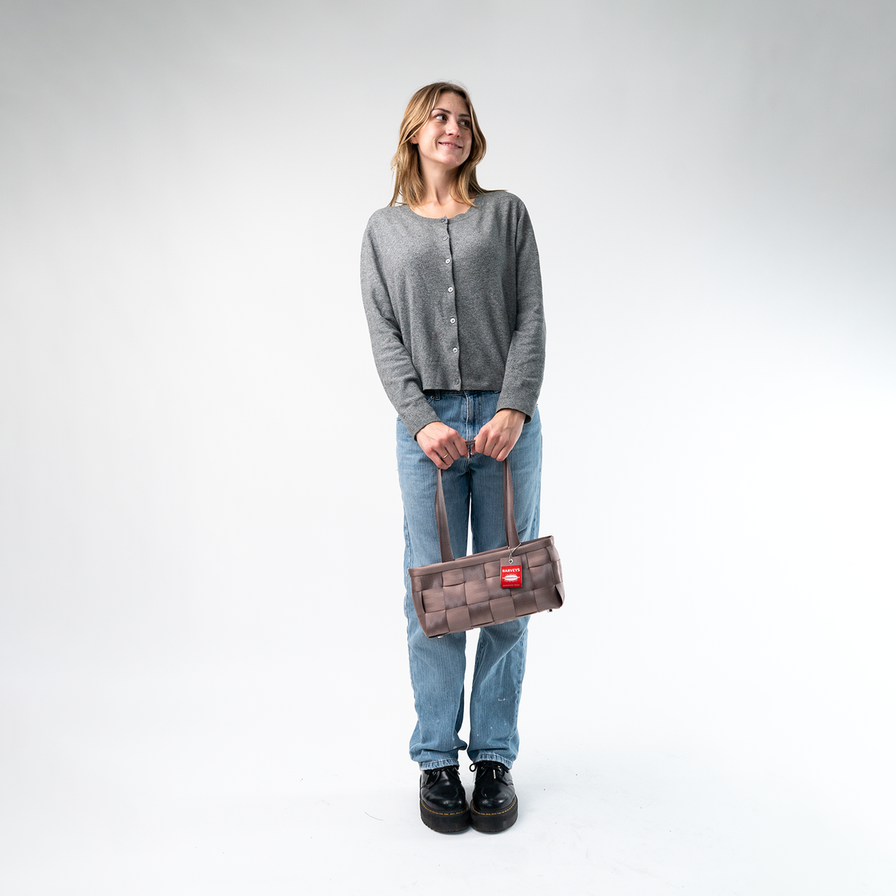 A Satchel in Taupe being held by a Model