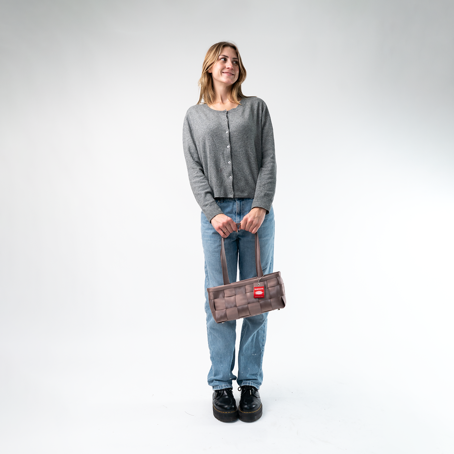A Satchel in Taupe being held by a Model