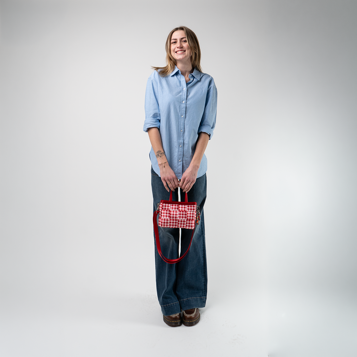 A Red Gingham Woven Petite Tote being used by a model